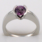 Platinum ring with v-cut semi-bezel-set round purple pastel sapphire on high-rise, flat-sided shank.