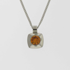 Platinum pendant with round orange diamond in square pillow bezel.