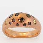 Brushed 14 karat rose gold ring with flush-set natural colored diamonds in gypsy-style shank.