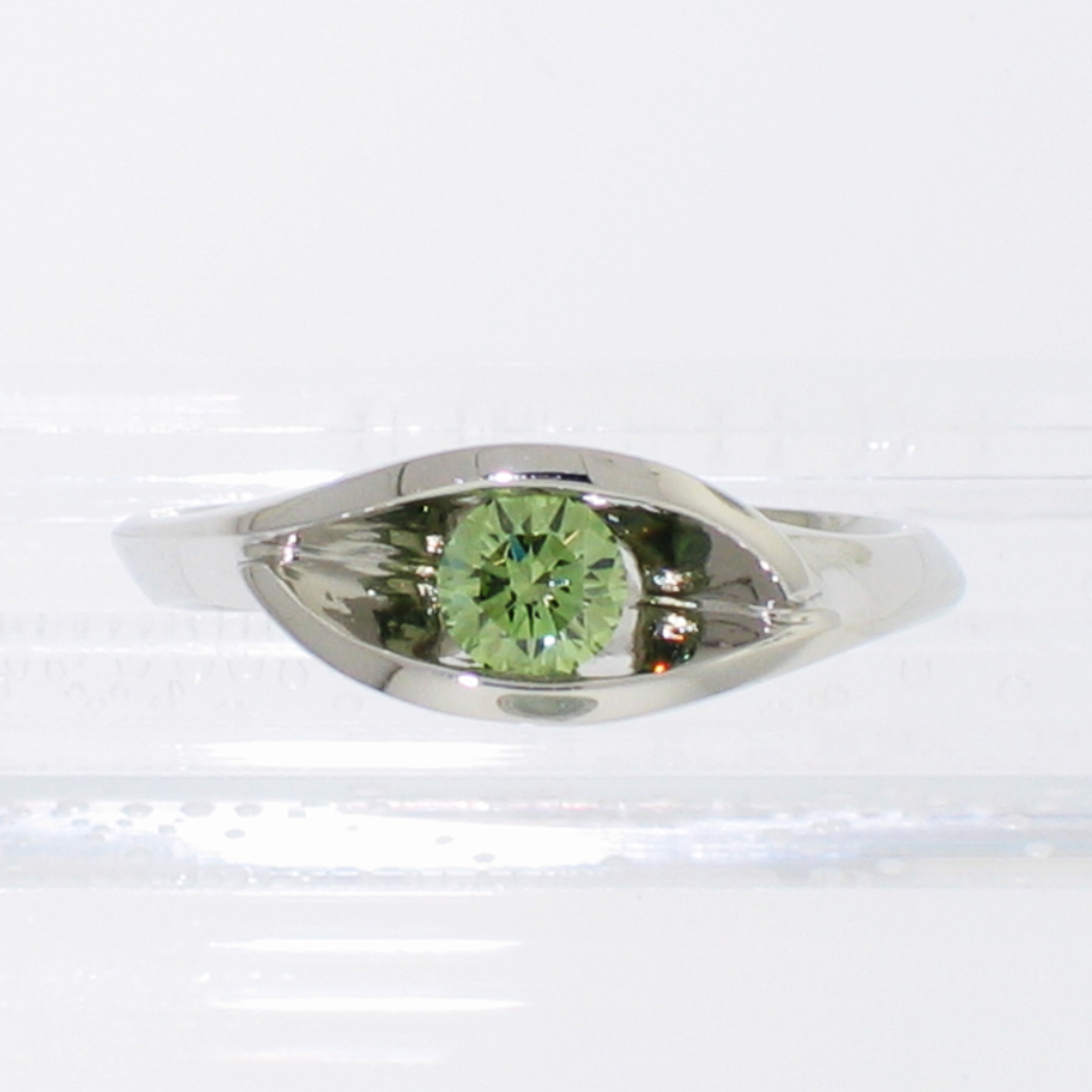 Platinum wrap-around v-shaped channel ring with channel-set iradiated green round brilliant diamond