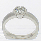 Palladium solitaire ring with 0.73ct round brilliant diamond in polished full bezel setting on matte-finished heavy round shank