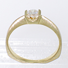 14 Karat yellow gold solitaire with round diamond in square saddle setting on pinched shank