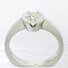 Platinum solitaire ring with round brilliant diamond set into v-cut semi-bezel setting on brushed shank