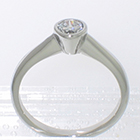Platinum solitaire ring with 0.25 ct round brilliant diamond in full bezel setting on smooth shank