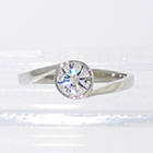 Platinum low-profile wrap-around bezel ring with 0.51 carat round-brilliant diamond set in low bezel