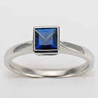Platinum solitaire with princess-cut blue sapphire in bezel setting