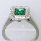 Platinum "halo" ring with square Emerald in full bezel and bead-set diamonds on halo plate around emerald