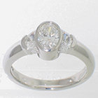 Platinum diamond ring with oval center and crescent moon-shaped sides.