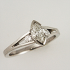 platinum split-shank ring with semi-bezel-set marquis-cut diamond and tapered channel of side stones