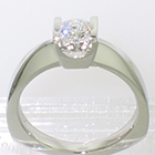 Platinum solitaire ring with round brilliant diamond channel-set into square saddle setting