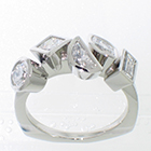 Platinum ring with assorted shapes and sizes of bezel-set diamonds.