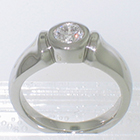 Platinum solitaire with 0.51 carat round brilliant diamond in full-bezel on thick shank with shoulders