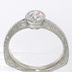 Platinum hand-engraved solitaire with 0.54 carat round brilliant diamond in full bezel