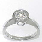 Palladium solitaire with 1 carat round brilliant diamond in full tapered bezel setting on pinched shank with corners