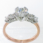 2-tone engagement ring with 5 round brilliant diamonds set in 4-prong platinum heads on 14 karat rose gold square-stock shank. Center stone= 0.66 carat round brilliant diamond