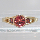 14 Karat 2-tone Yellow and Rose Gold 3-stone ring with round Padparadscha Sapphire in full bezel setting and orange diamonds channel-set into split-shank (alternate view)