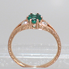 14 Karat Rose Gold 3-stone ring with round Emerald in 6-prong "gallery" style setting with round white diamonds channel-set into split-shank