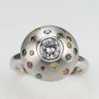 Platinum pillow-style ring with flush set colored diamonds in brushed metal finish.