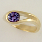 yellow gold oblong channel-set oval purple sapphire ring.