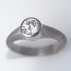 1ct. set into a bezel on a textured tapered band