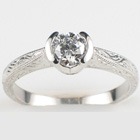 Platinum hand-engraved ring with 0.52 carat round diamond in semi-bezel.