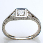 Platinum split-shank ring with 0.52 ct. princess-cut diamond in low profile bezel with 0.24 carat total weight trillion-shaped side diamonds channel-set into split shank.