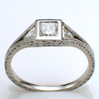 Platinum split-shank ring with 0.52 ct. princess-cut diamond in low profile bezel with 0.24 carat total weight trillion-shaped side diamonds channel-set into split shank.