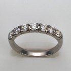 Platinum diamond band with round diamonds in square heads.