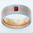 Brushed Platinum band with 14 karat rose gold inlay and flush-set emerald-cut ruby.