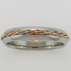 Platinum comfort-fit band with 14 karat tri-colored gold twist inlay.