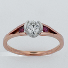14 karat rose gold split-shank ring with round brilliant diamond in platinum semi-bezel and pink diamonds channel-set into split shank.
