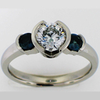 Platinum ring with round diamond and round natural color-changing alexandrites in bezels.