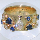 14 Karat Yellow Gold multi-bezels band with oval-shaped diamond center and diamonds and sapphires in various shapes and sizes set around band