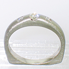 Palladium 3-stone ring with round brilliant diamonds flush-set in brushed heavy shank