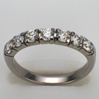 Platinum diamond band with round diamonds in square heads.