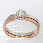 Platinum solitaire ring with half-overhanging bezel to allow a band to fit underneath (pictured with flat high-polished 14 karat rose gold band)