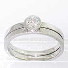 Platinum solitaire ring with half-overhanging bezel to allow a band to fit underneath (pictured with flat hammered palladium band)