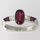 Pink Sapphire Ring with round Diamonds and Pink Sapphire pear-shaped side stones in Palladium