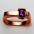 14 karat rose gold flat-top ring with off-center rectangular pink sapphire in semi-bezel.