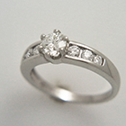 platinum six-prong diamond ring with tapered channel-set diamonds.