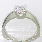 Platinum solitaire ring with round brilliant diamond channel-set into square saddle setting