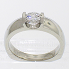 Platinum solitaire with 0.72 carat round brilliant diamond channel-set into low-profile saddle setting