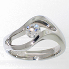 Palladium solitaire ring with 0.46 ct round brilliant diamond channel-set in open "subtle wave" freeform setting