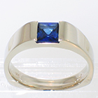 1.1 carat princess-cut sapphire flush-set in heavy 14 karat white gold flat shank