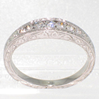 Platinum hand-engraved tapered channel band with round diamonds