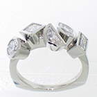 Platinum ring with assorted shapes and sizes of bezel-set diamonds.