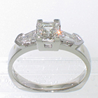 Platinum 3-stone ring with 0.80 carat ascher-cut diamond in 4-prong cut-out bezel-setting and 0.45 carat step-cut tapered bullet baguettes
