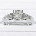 Platinum hand-engraved cathedral ring with 0.73 carat princess-cut diamond in semi-bezel with 0.24 carat of round melee diamonds channel-set in shank