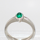 Platinum Solitaire ring with oval-shaped caboschon-cut emerald in full bezel setting