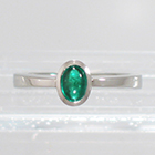 Platinum Solitaire ring with oval-shaped caboschon-cut emerald in full bezel setting